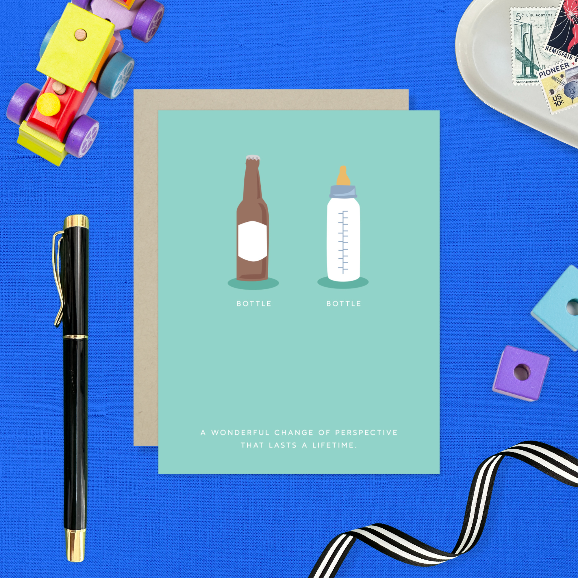 Baby greeting card with beer and baby bottle and 'a wonderful change of perspective that lasts a lifetime' text