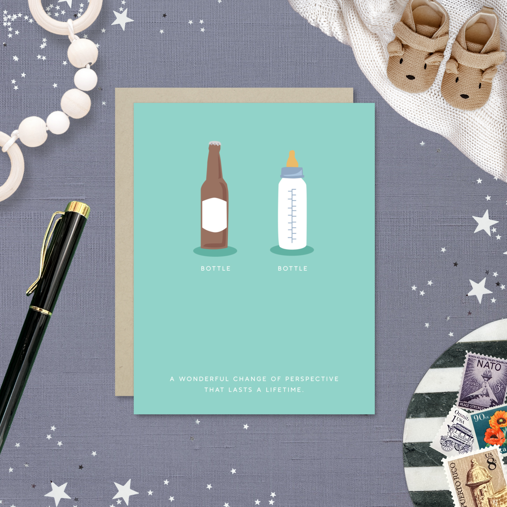 Baby greeting card with beer and baby bottle and 'a wonderful change of perspective that lasts a lifetime' text