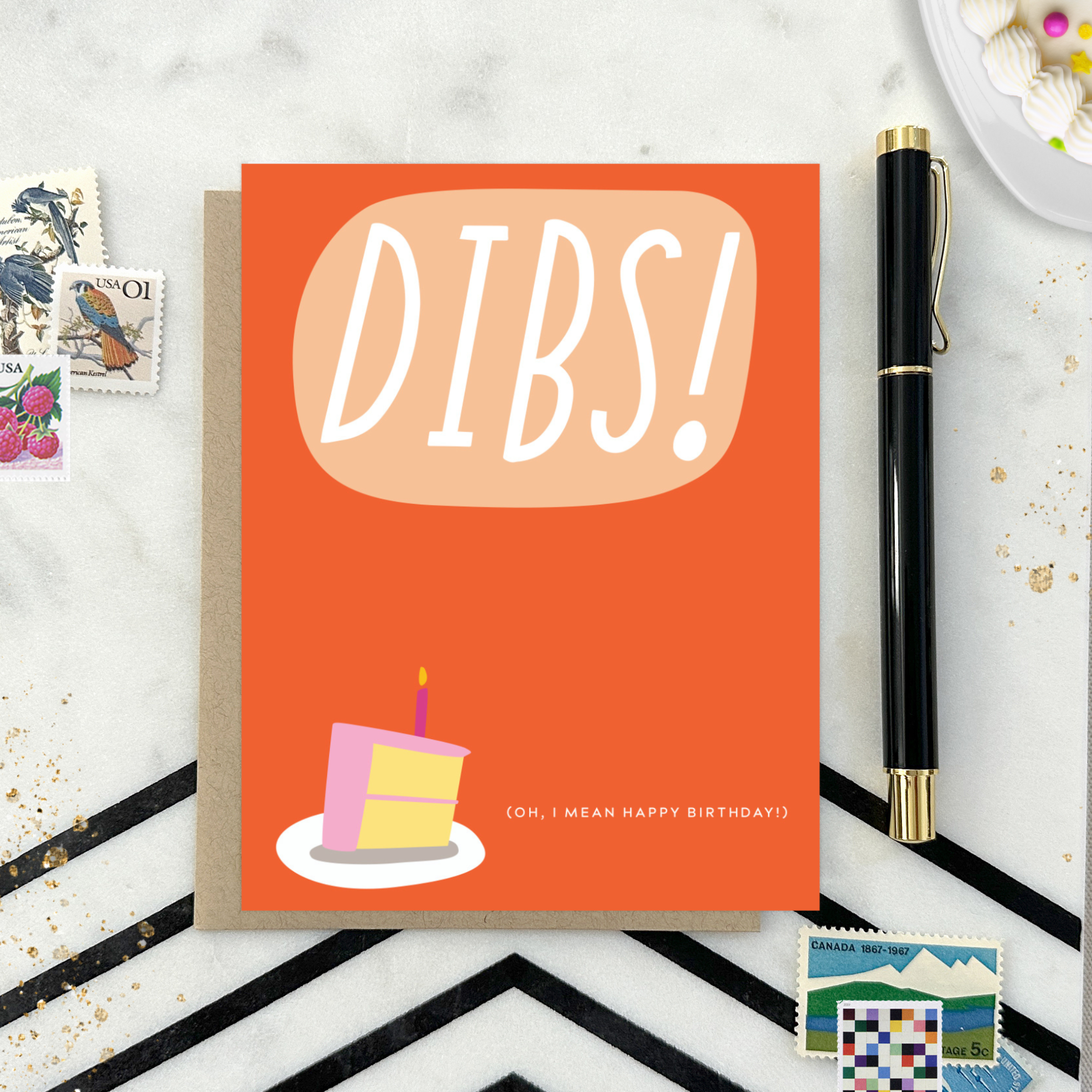 Card with 'DIBS! (Oh, I mean happy birthday! )' text and a cake illustration on an orange background.