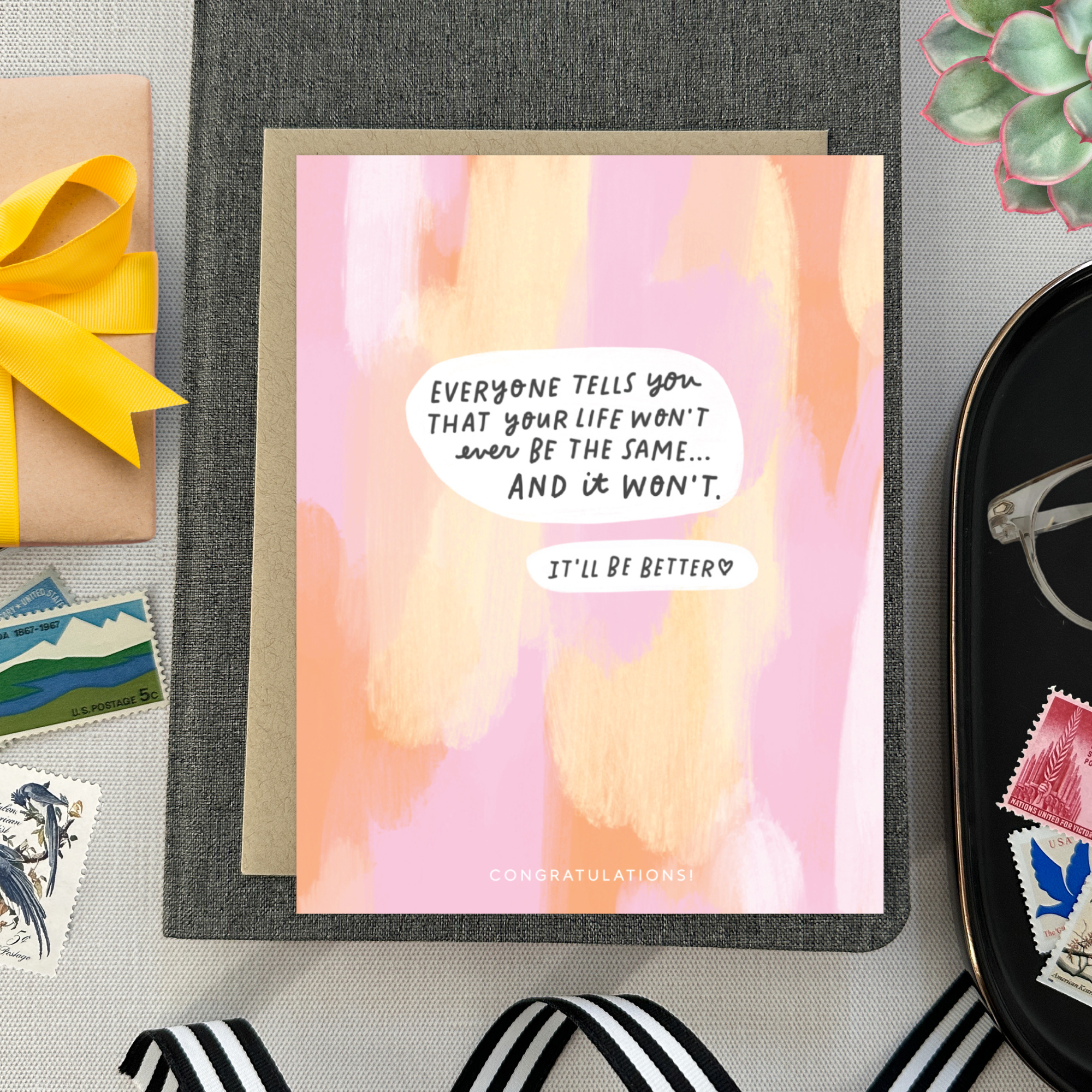 Baby greeting card with paint smear background and 'everyone tells you that your life won't ever be the same...' text
