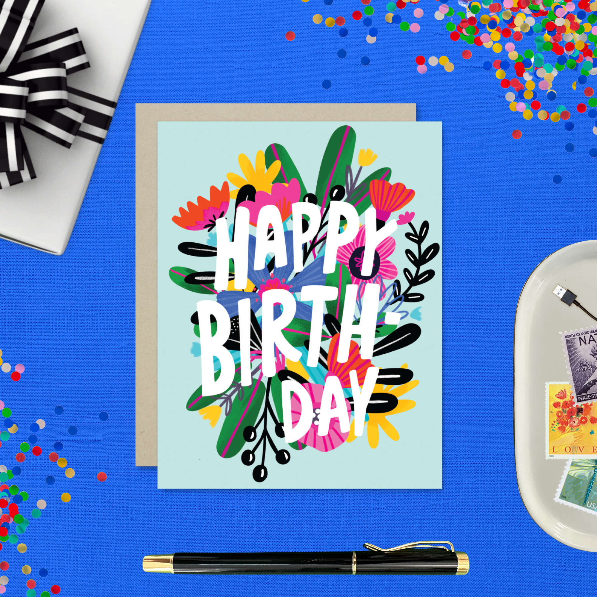 A colorful birthday greeting card with a floral design and the text 'HAPPY BIRTHDAY' on a light blue background.