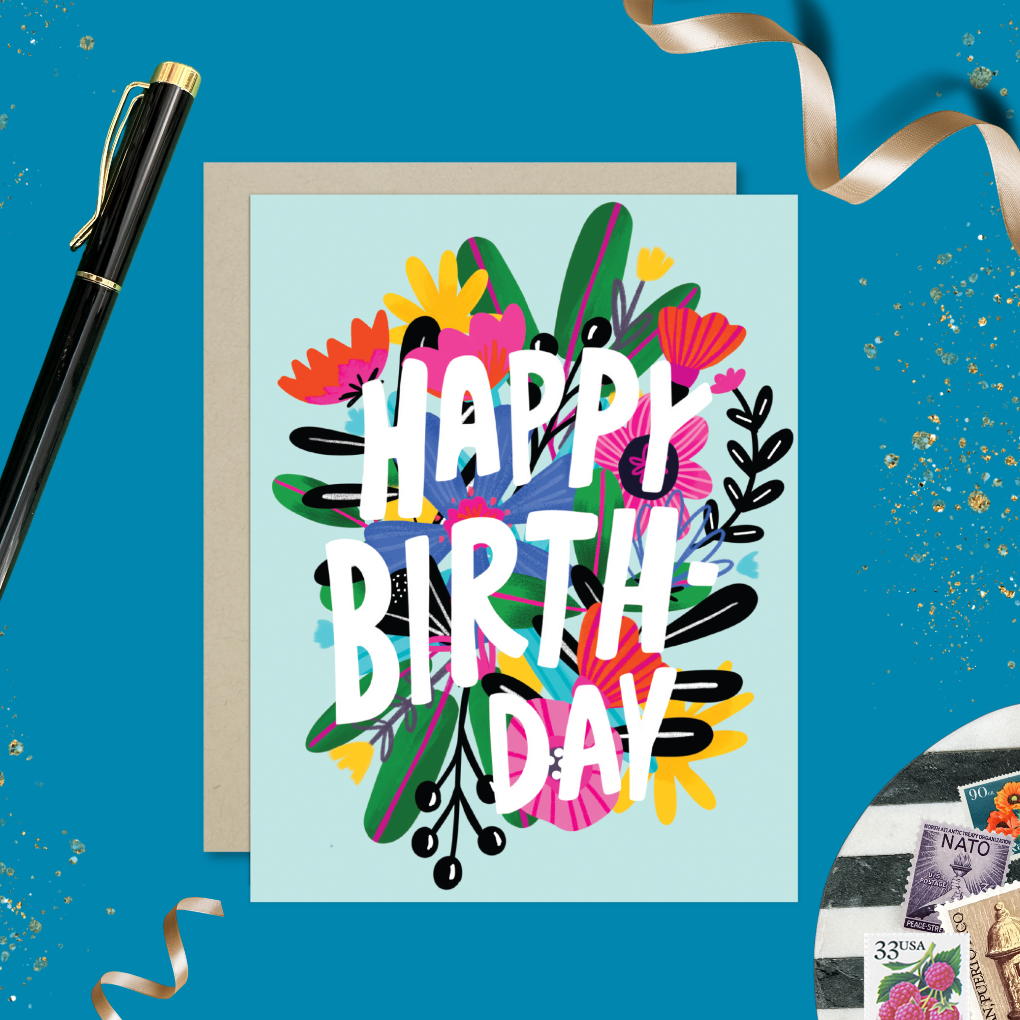 A colorful birthday greeting card with a floral design and the text 'HAPPY BIRTHDAY' on a light blue background.