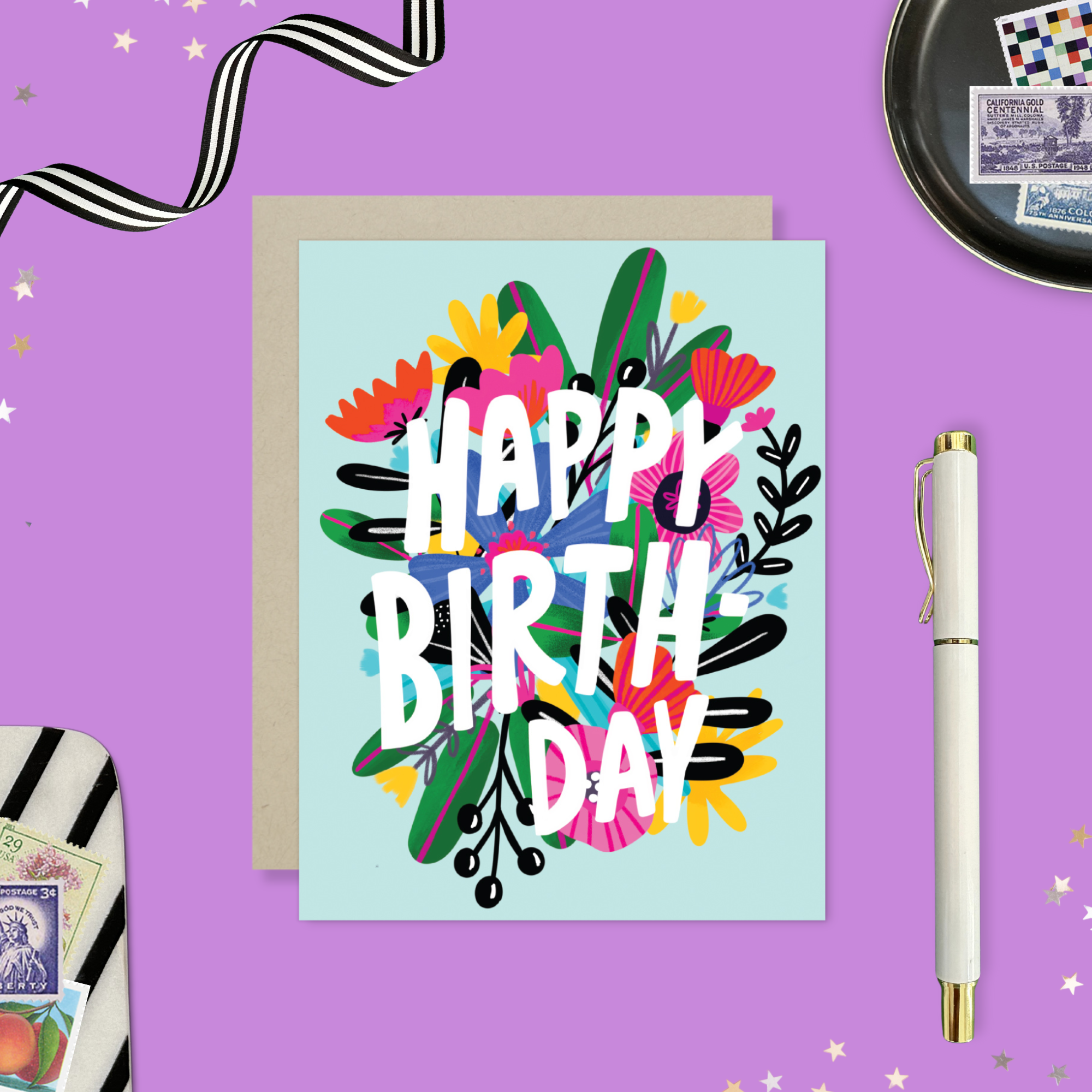 A colorful birthday greeting card with a floral design and the text 'HAPPY BIRTHDAY' on a light blue background.