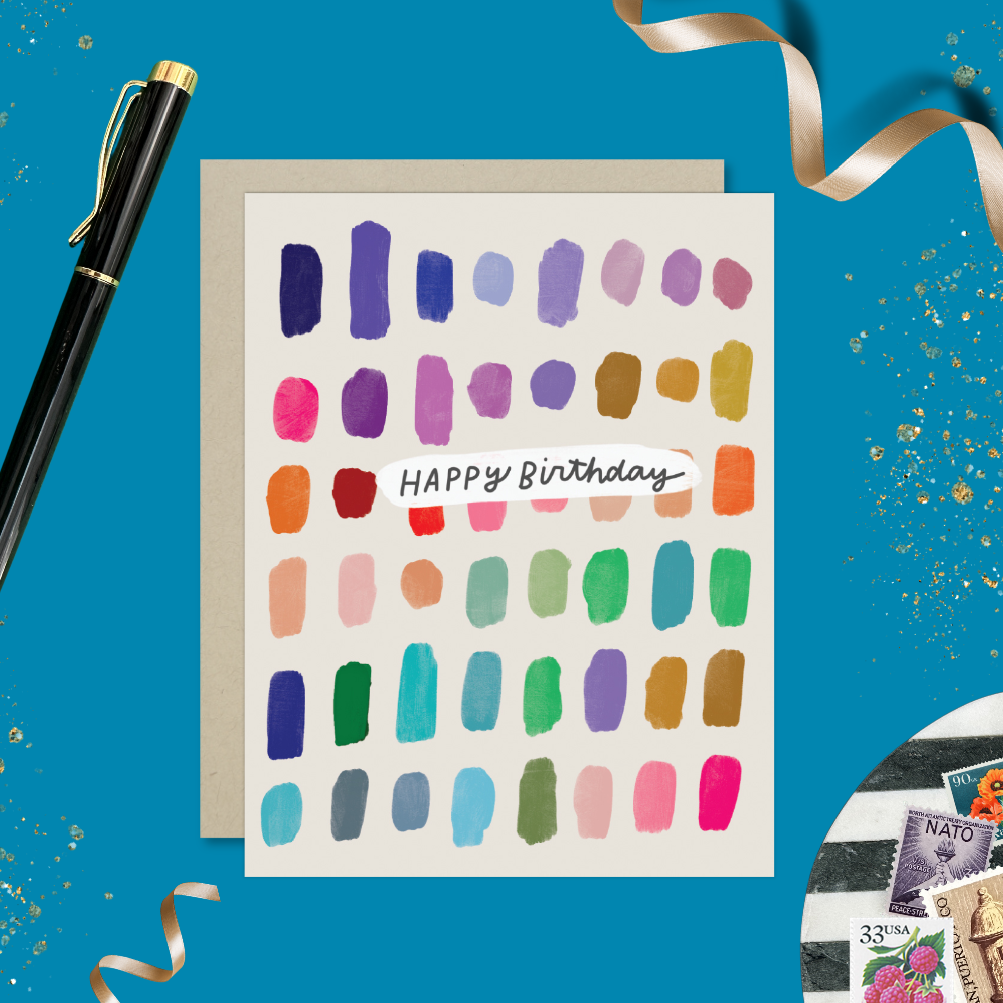 A colorful birthday card with paint swatch-like designs in various colors and the text 'Happy Birthday' on it.