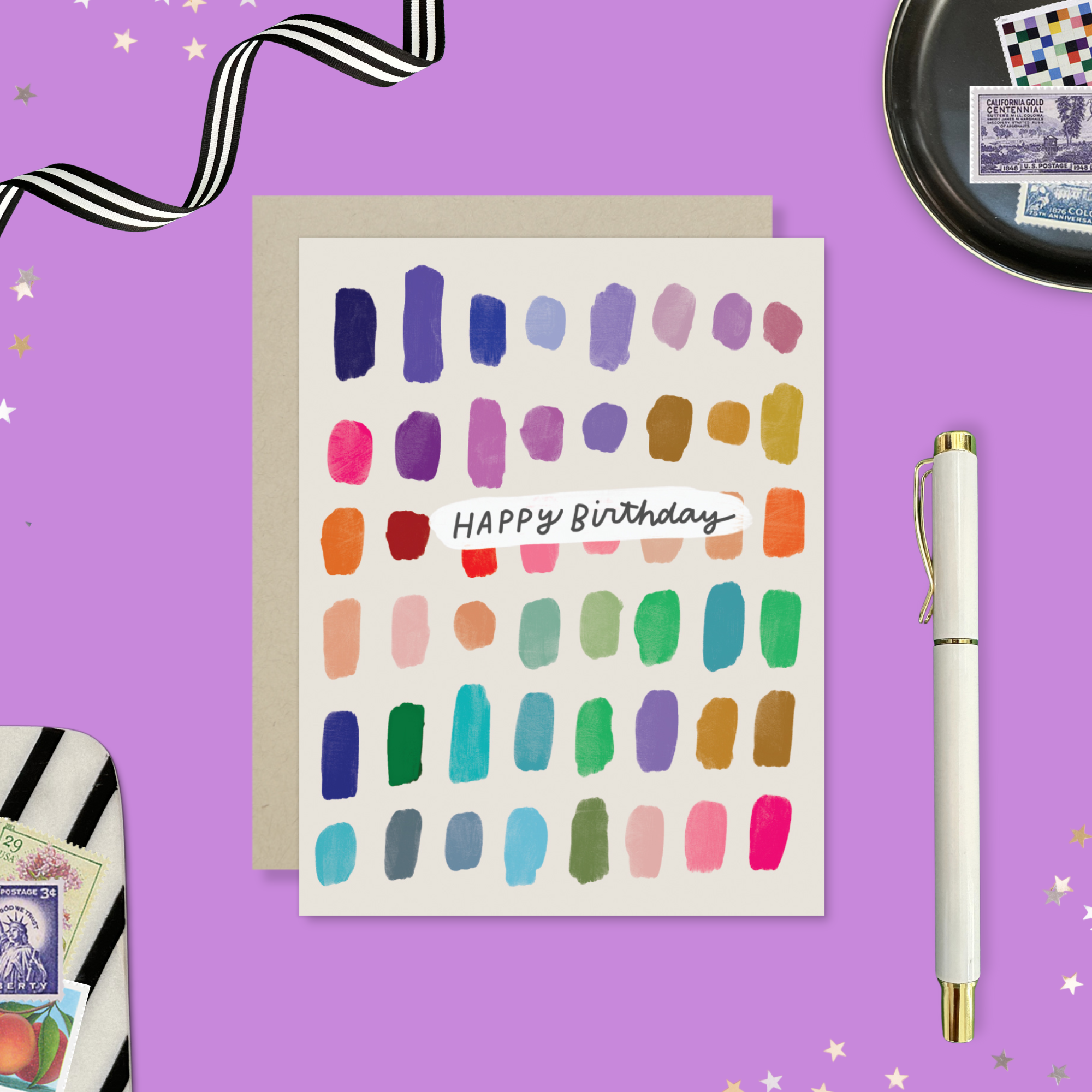 A colorful birthday card with paint swatch-like designs in various colors and the text 'Happy Birthday' on it.