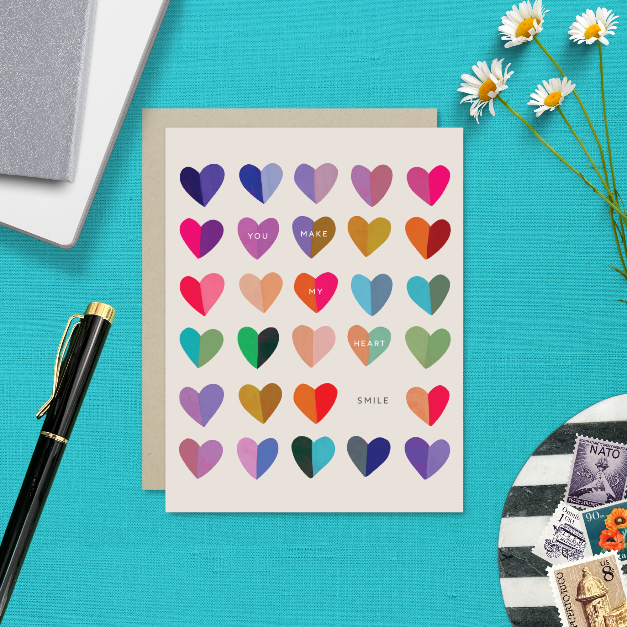 A valentines day greeting card with a cheerful grid of colorful hearts and the message 'You make my heart smile' written on it.