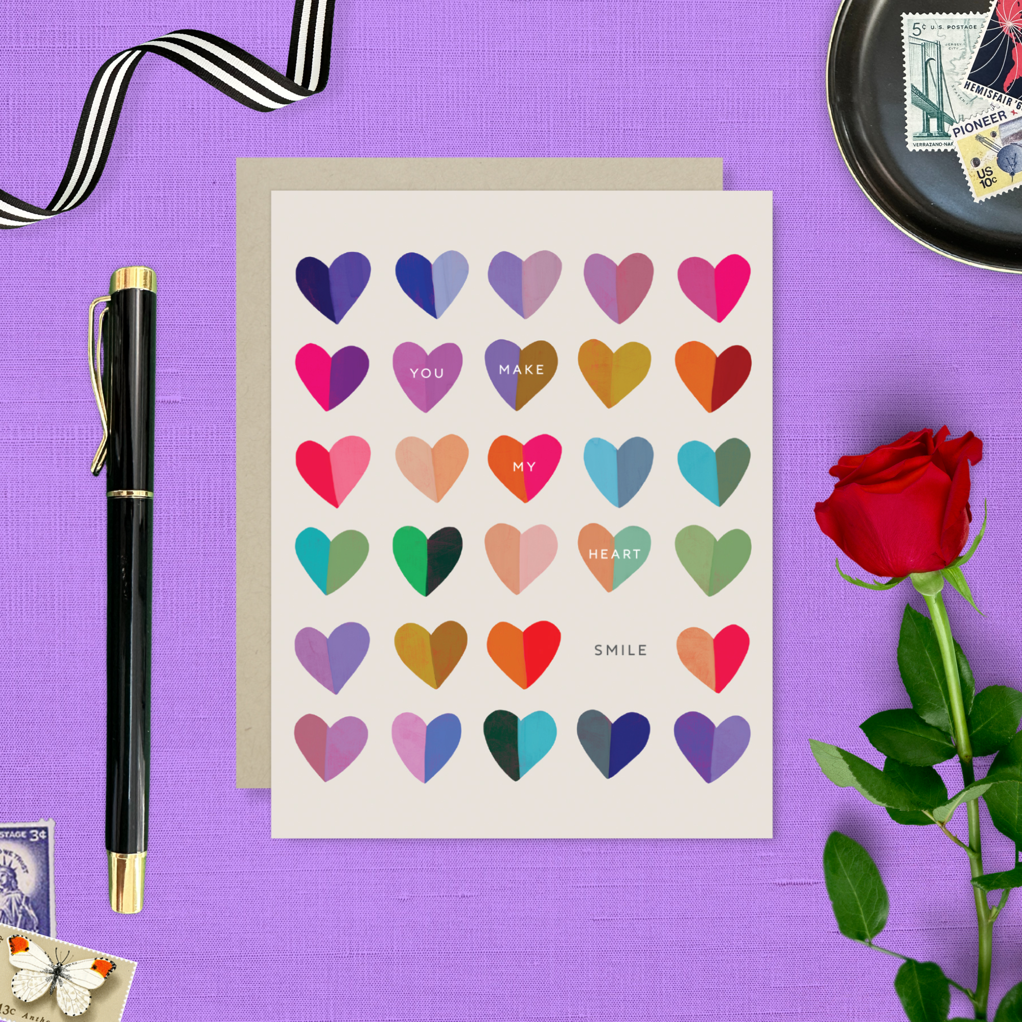 A valentines day greeting card with a cheerful grid of colorful hearts and the message 'You make my heart smile' written on it.