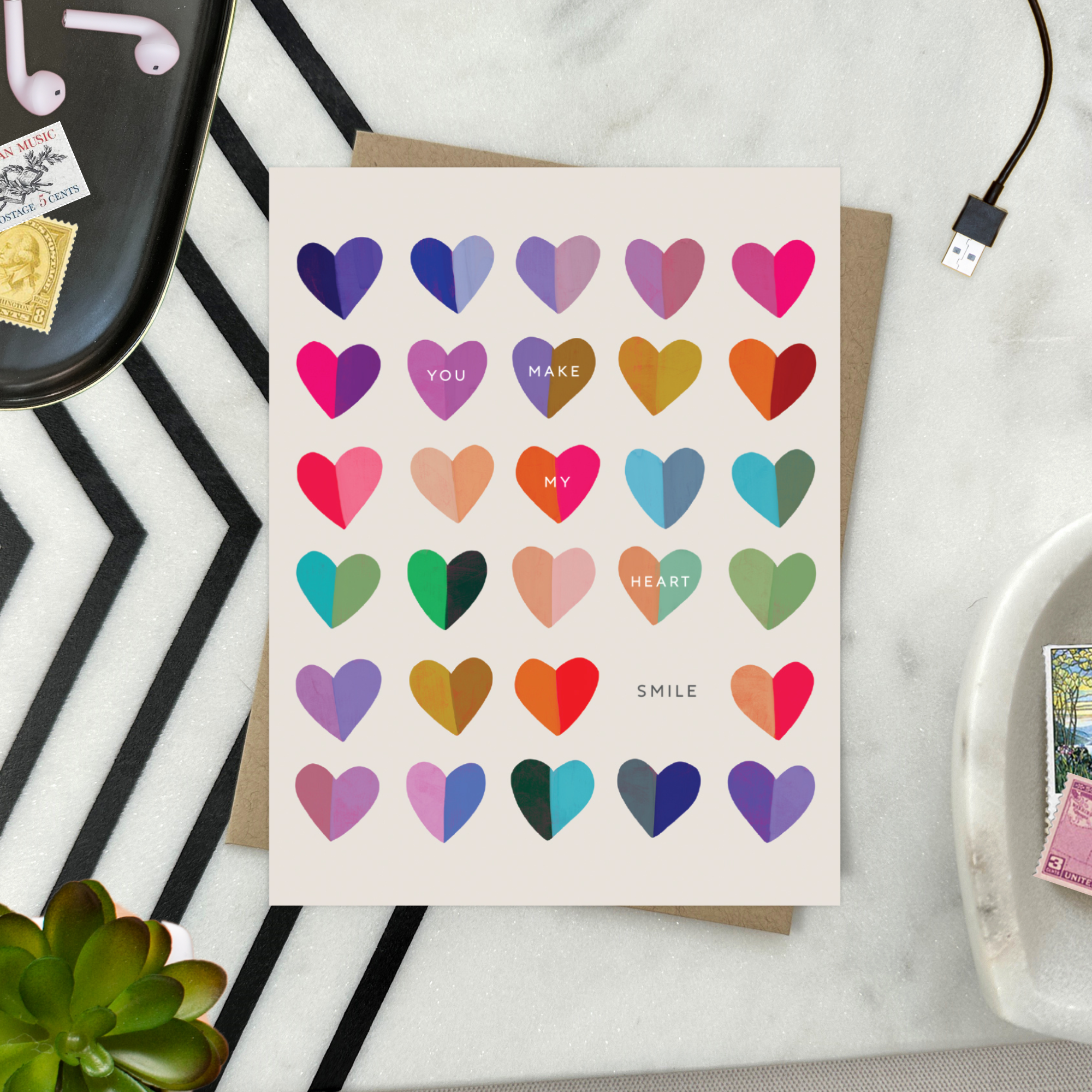 A valentines day greeting card with a cheerful grid of colorful hearts and the message 'You make my heart smile' written on it.