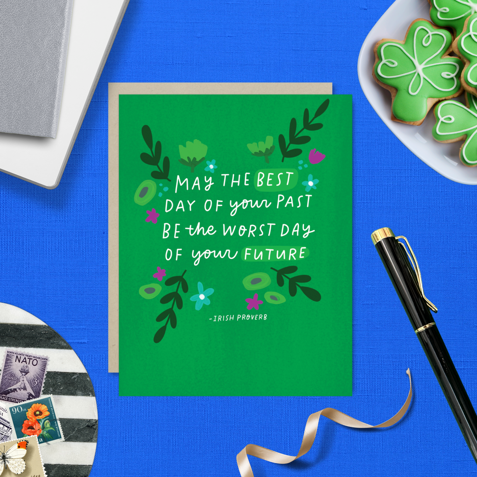 A St. Patricks day greeting card with floral patterns and a hand-lettered Irish proverb.