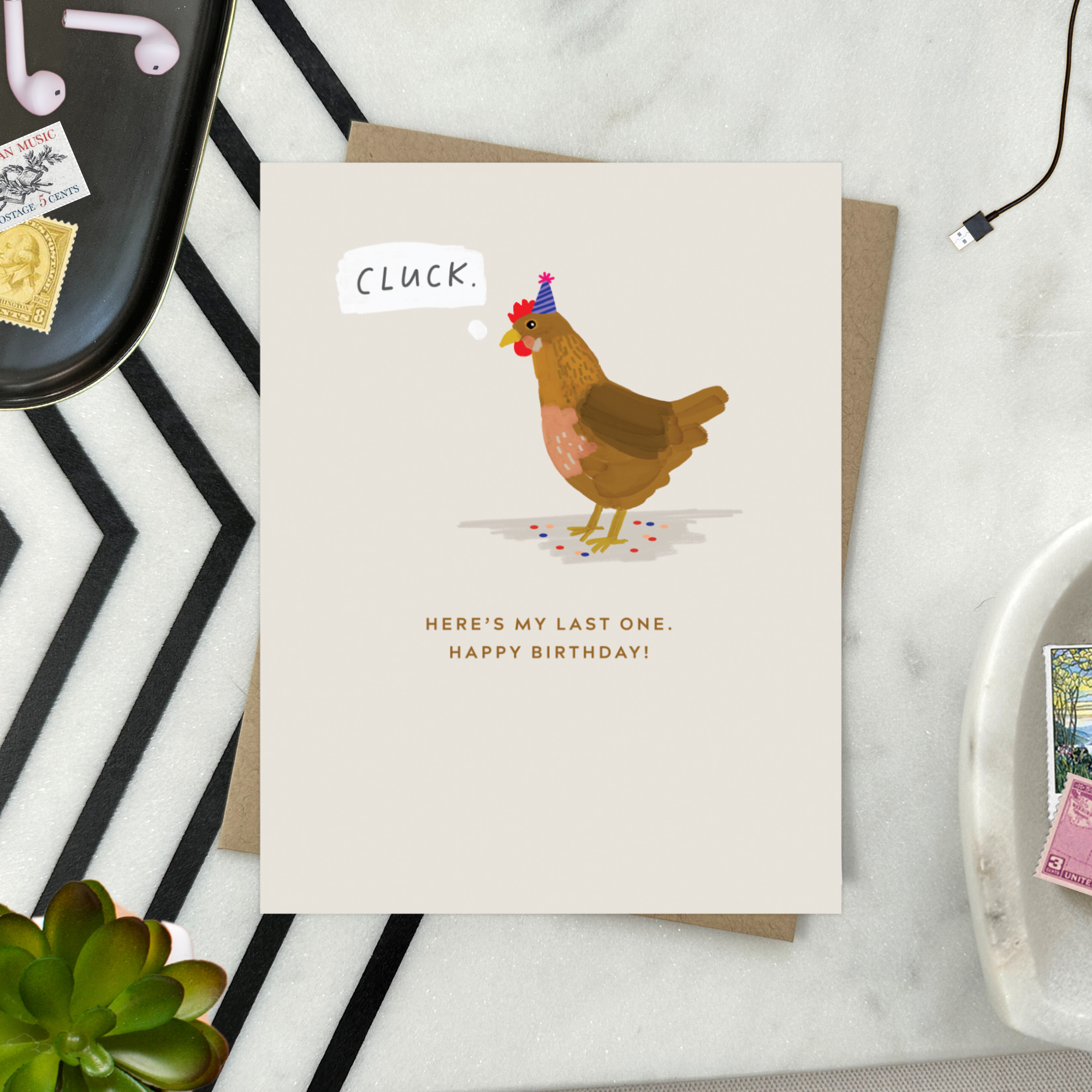 A funny birthday greeting card with an illustration of a chicken wearing a birthday hat, with the text 'Cluck. Here's my last one'