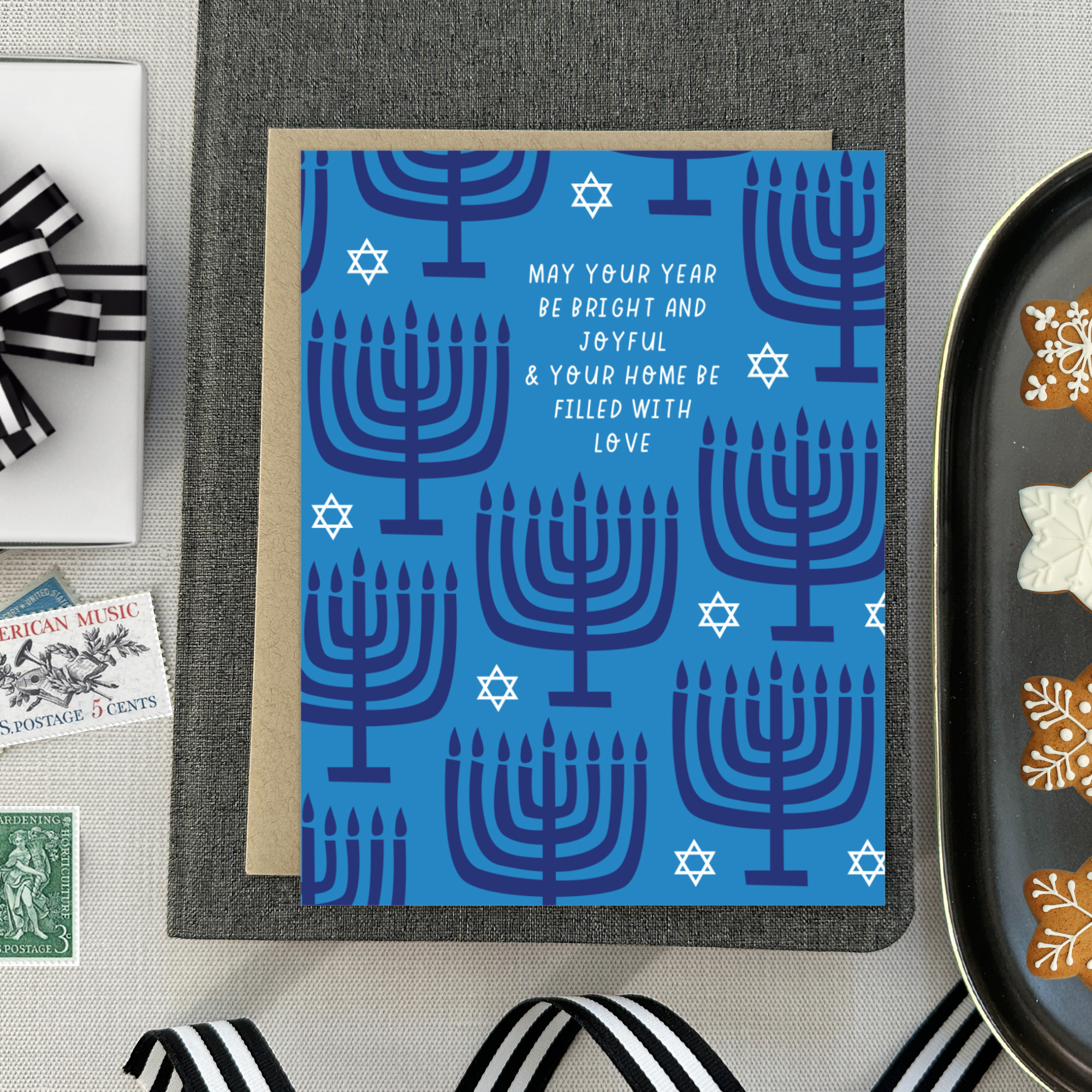 Hannukah greeting card with menorahs and stars of David scattered with 'may your year be bright and joyful & your home be filled with love' text