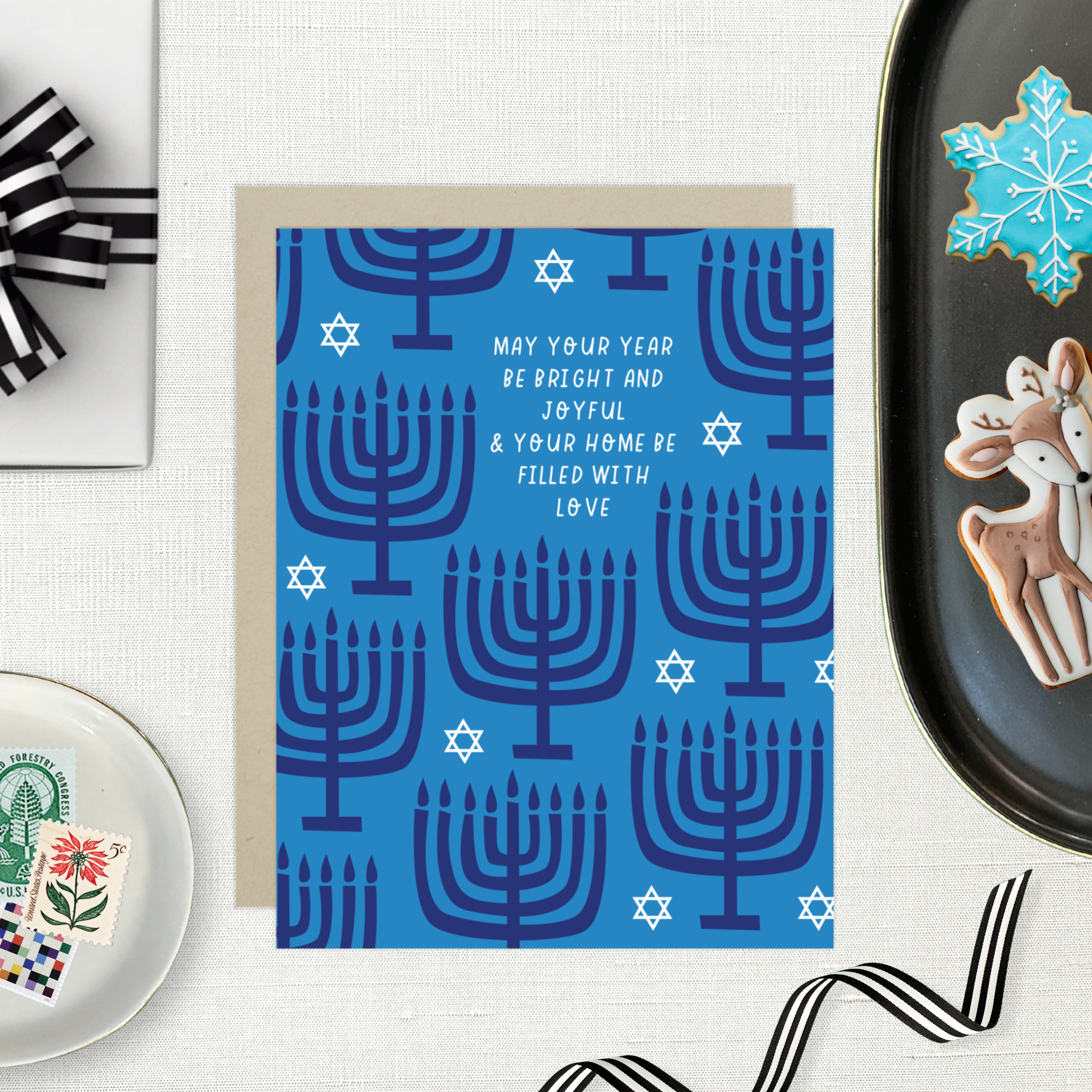Hannukah greeting card with menorahs and stars of David scattered with 'may your year be bright and joyful & your home be filled with love' text