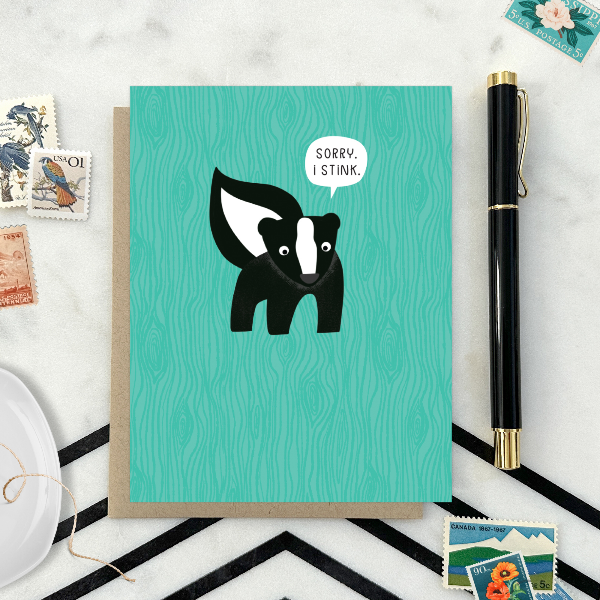 A sorry greeting card with an illustration of a skunk and the text 'Sorry I Stink' on a teal background.