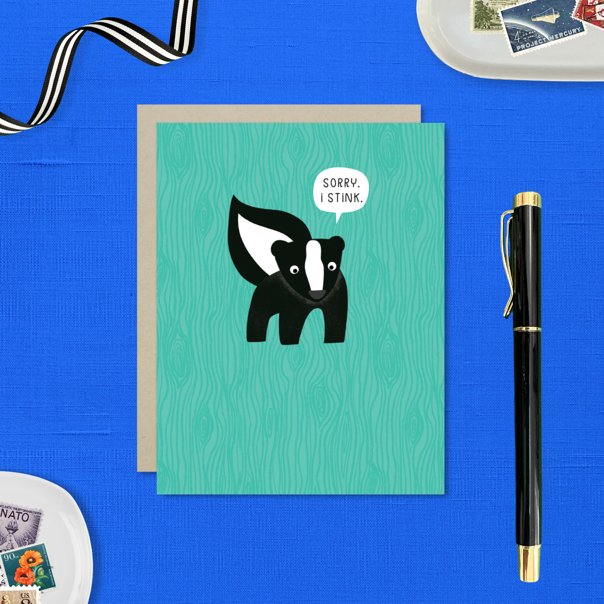 A sorry greeting card with an illustration of a skunk and the text 'Sorry I Stink' on a teal background.