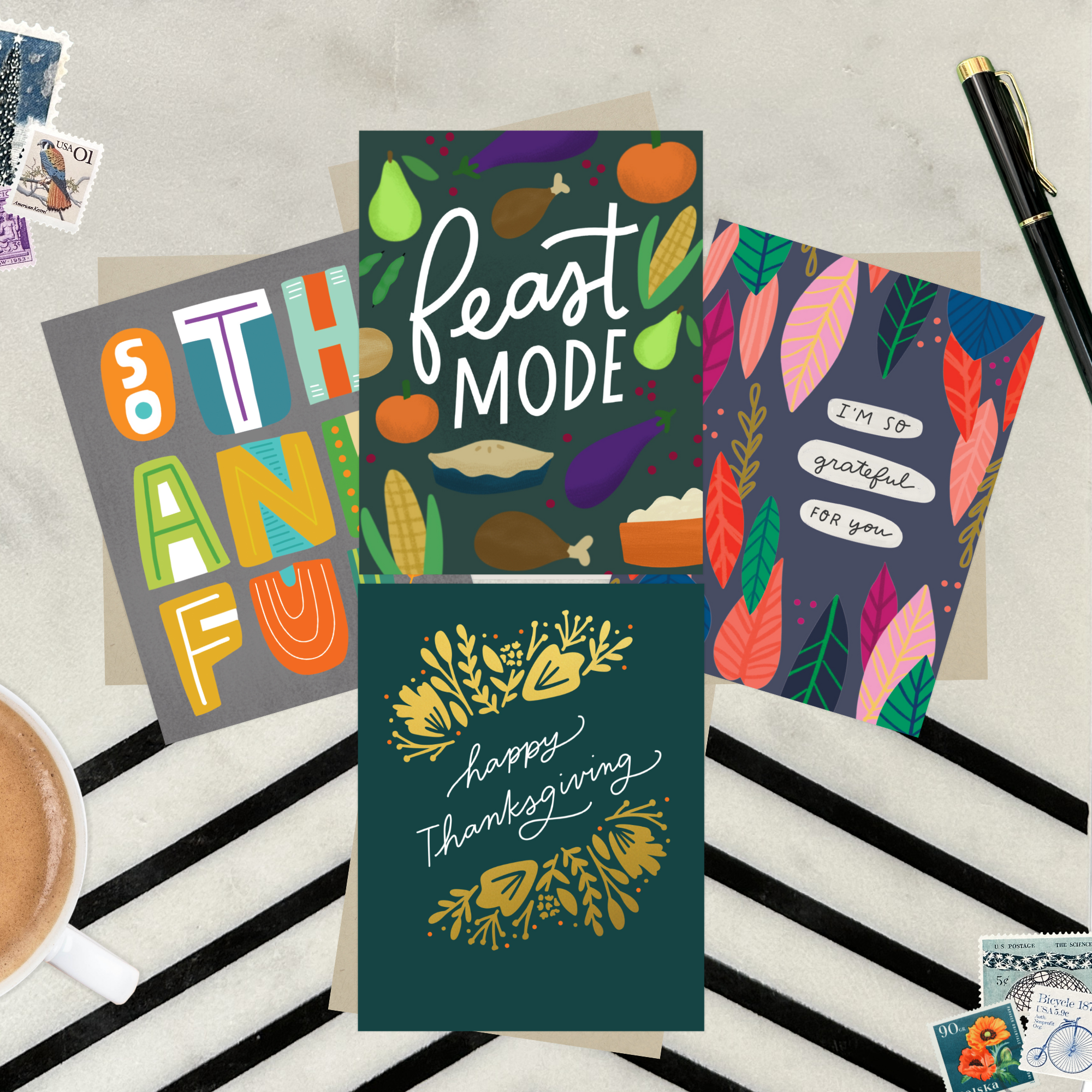Four colorful greeting cards with Thanksgiving-themed designs on a striped surface featuring "I'm so grateful for you," "Happy Thanksgiving," "Feast Mode," and "So Thankful."