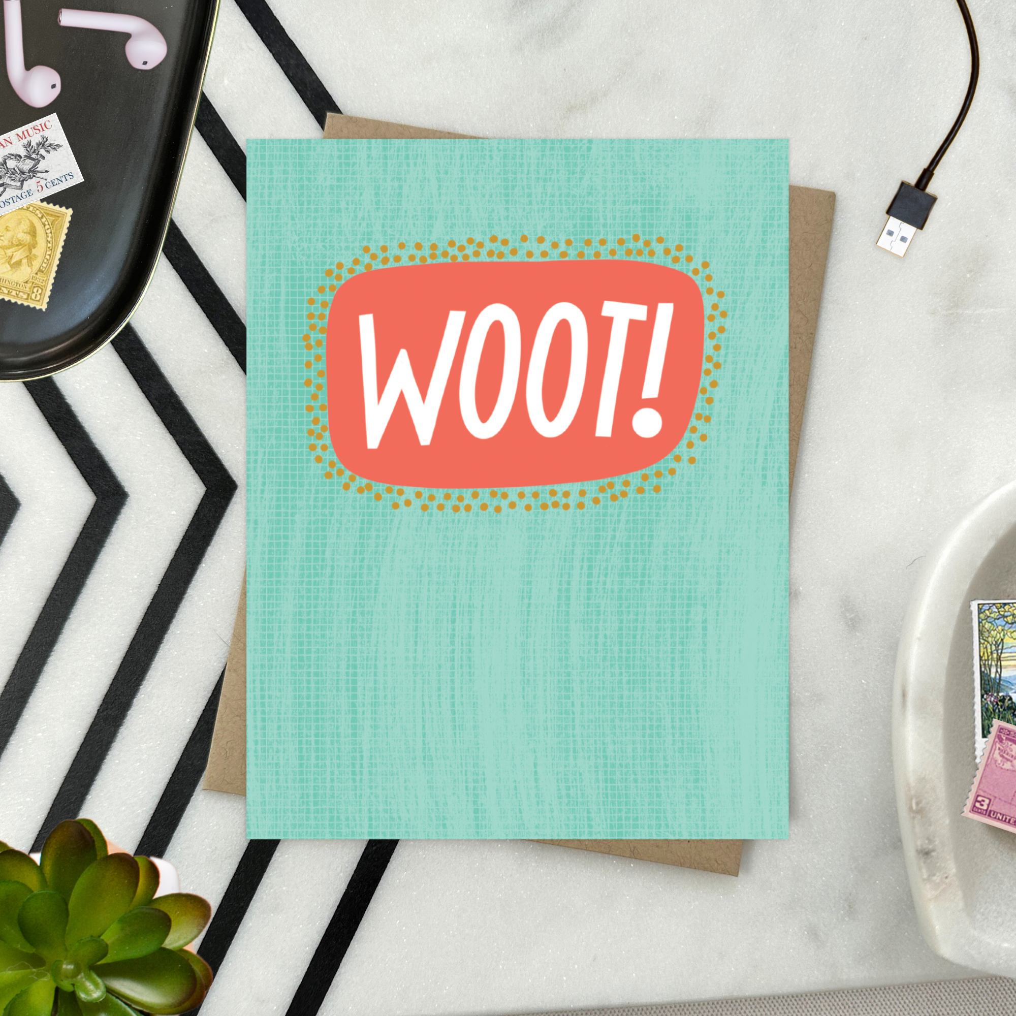 A congratulations greeting card with a hand-lettered word 'Woot!' written in bold, fun typography on a teal background with a textured appearance.