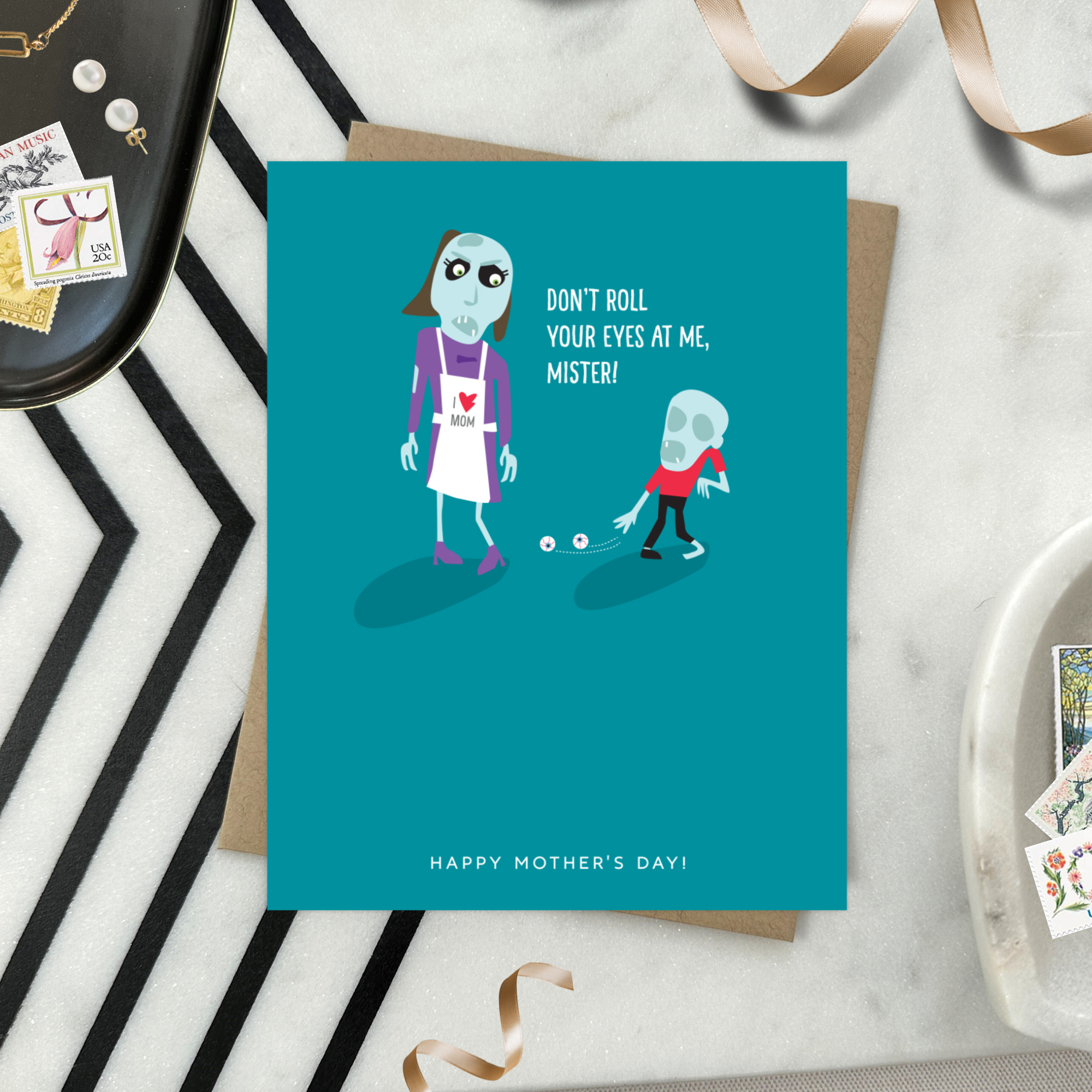 Mothers day greeting card with 2 zombies, one's eyes on the floor text 'don't roll your eyes at me, mister..happy mothers day'