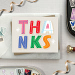 Thank you card featuring playful and colorful lettering with the word thanks. 