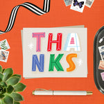 Thank you card featuring playful and colorful lettering with the word thanks. 
