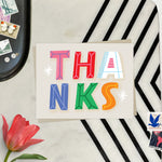 Thank you card featuring playful and colorful lettering with the word thanks. 