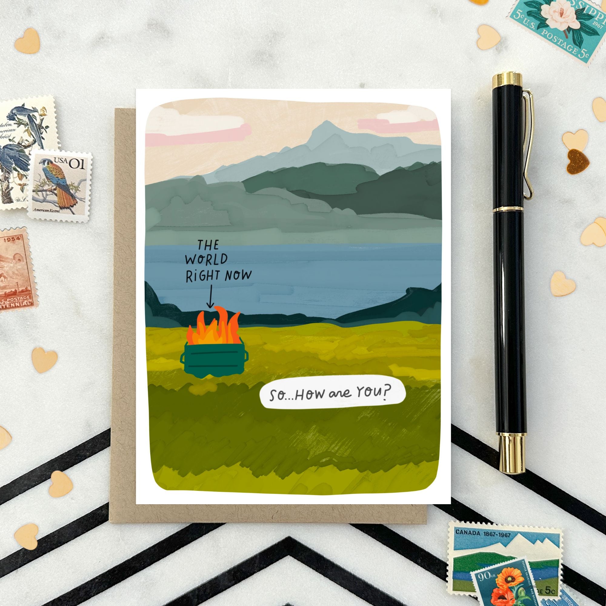 Greeting card with illustrated scenic landscape and a dumpster fire labeled “The World Right Now” with the caption “So… how are you?”