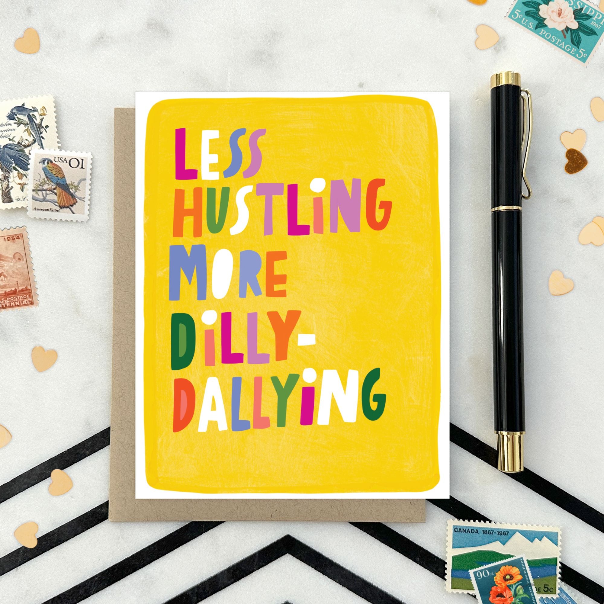 Greeting card with hand-lettered text “Less Hustling, More Dilly-Dallying” on bright yellow painterly background