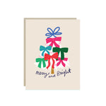 Christmas card with a white evergreen tree trimmed in ribbon bows and the hand-lettered words 'merry and bright'.