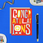 A colorful congratulations greeting card with the word 'CONGRATULATIONS' written in bold, playful lettering, predominantly in red, with additional decorative elements like stars.