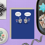 Hannukah greeting card with 2 dreidels drinking. One is saying '8 crazy nights' the other says 'woohoo!'