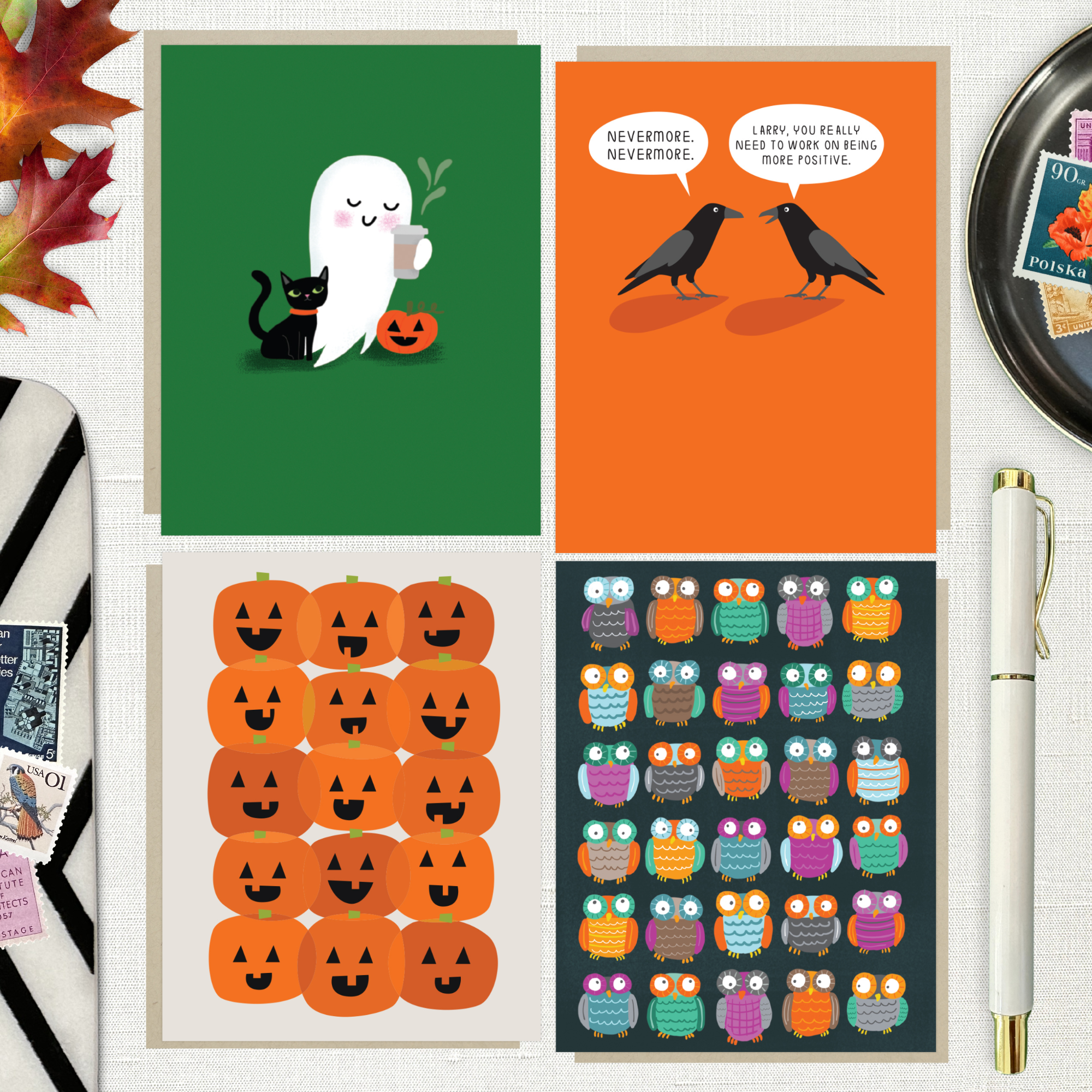 Collection of Halloween-themed greeting cards with a pen and autumn leaves featuring an adorable ghost with black cat and coffee, one with 2 funny ravens saying "Nevermore," one with a jack-o-lantern pattern, and one with an owl pattern on a white linen background.