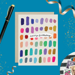 A colorful birthday card with paint swatch-like designs in various colors and the text 'Happy Birthday' on it.