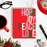A red holiday greeting card with the words 'HOPE, JOY, PEACE, LOVE' stacked in a graphic design.