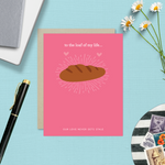 A Valentine's day greeting card with a illustration of a loaf of bread and the text 'to the loaf of my life... Our love never gets stale.'