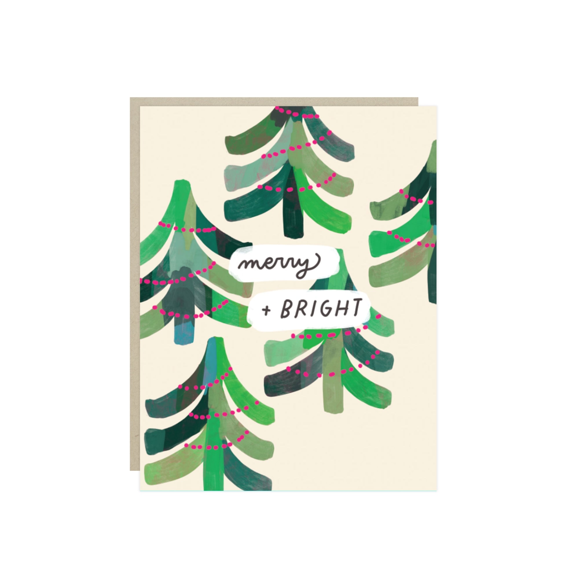 Christmas card with painterly evergreen trees strung with pink lights and the hand-lettered words 'merry + bright'.