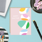 Easter greeting card with stack of eggs and 'happy easter' text