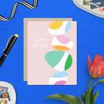 Easter greeting card with stack of eggs and 'happy easter' text