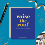 A birthday greeting card with 'raise the roof' printed in gold foil. Below it, in smaller gold foil text, reads 'Just don’t throw out your back.